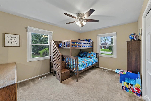 carpeted bedroom featuring baseboards, ceiling fan, and visible vents