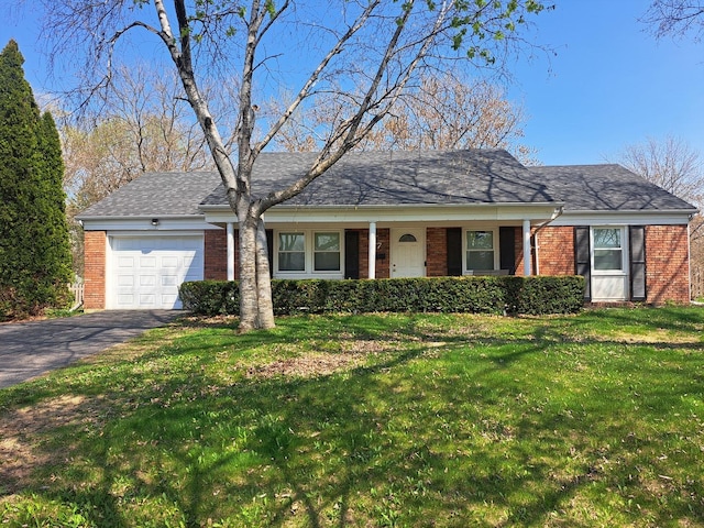 ranch-style house featuring brick siding, an attached garage, driveway, and a front yard