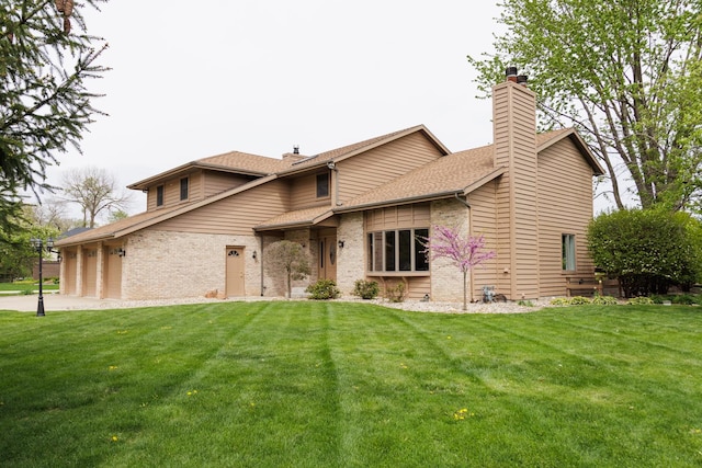 view of front facade featuring brick siding, an attached garage, a front lawn, and a chimney
