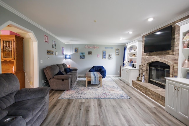 living area with light wood-style floors, a fireplace, and ornamental molding