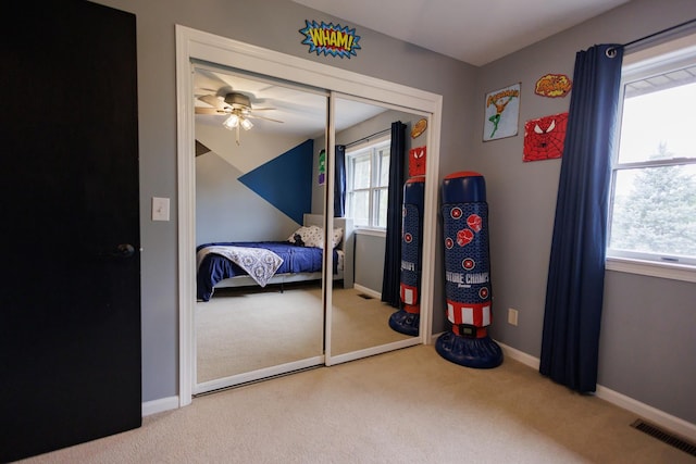 bedroom featuring carpet flooring, multiple windows, visible vents, and a closet