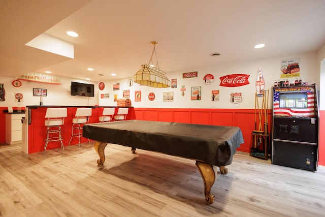 game room with pool table, recessed lighting, wainscoting, wet bar, and light wood-type flooring