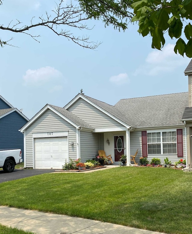 ranch-style house with a front yard, a shingled roof, an attached garage, and aphalt driveway