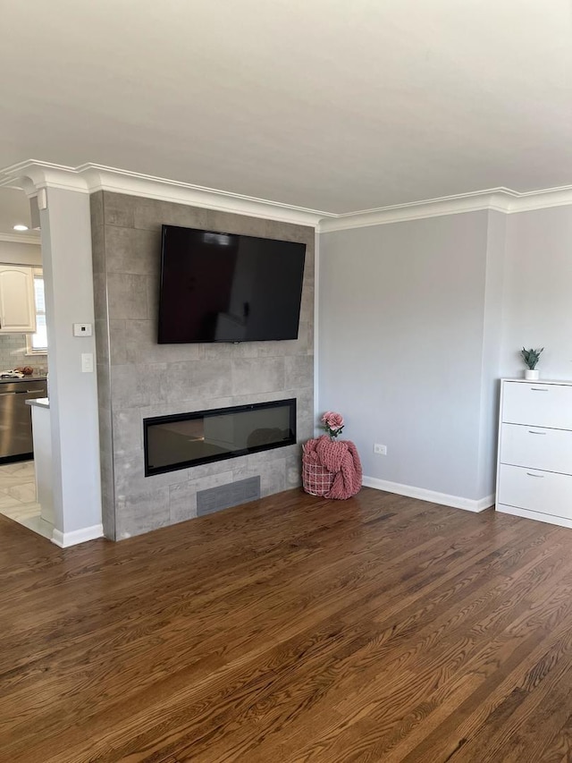 unfurnished living room with wood finished floors, crown molding, and a fireplace