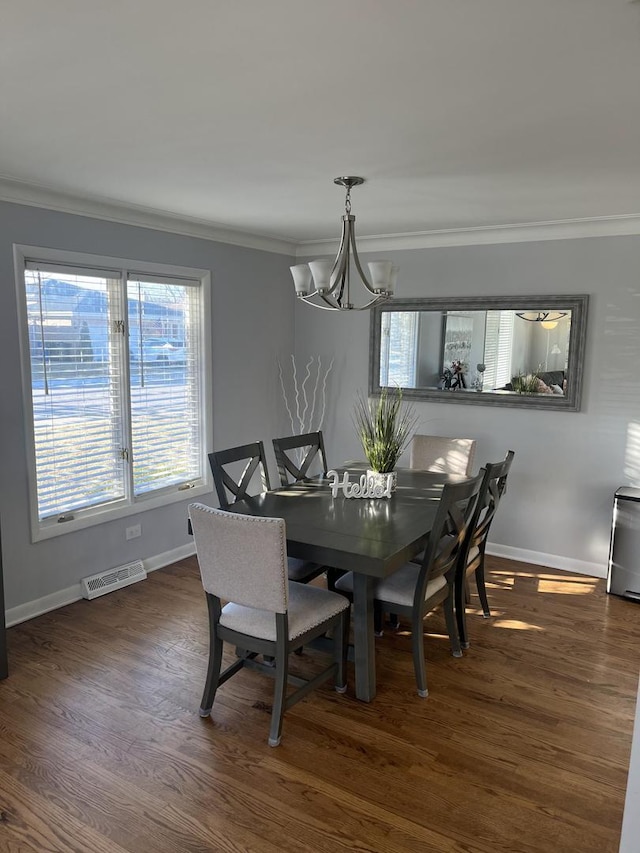 dining room featuring visible vents, baseboards, ornamental molding, and a notable chandelier