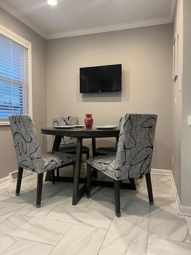 dining space with baseboards, ornamental molding, and marble finish floor