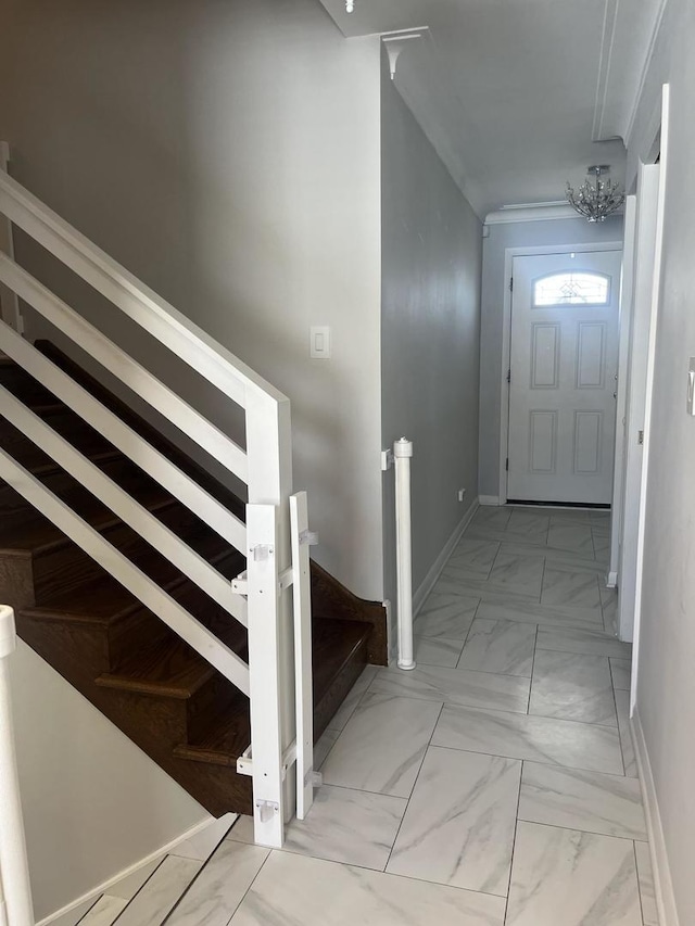 staircase featuring a notable chandelier, marble finish floor, and baseboards
