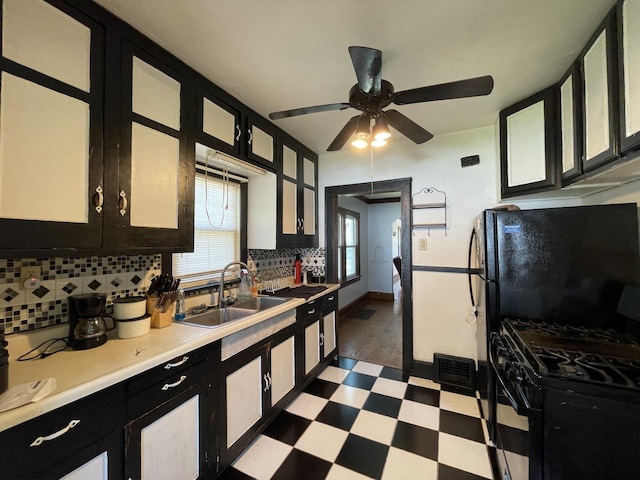 kitchen with decorative backsplash, dark floors, light countertops, black appliances, and dark cabinetry