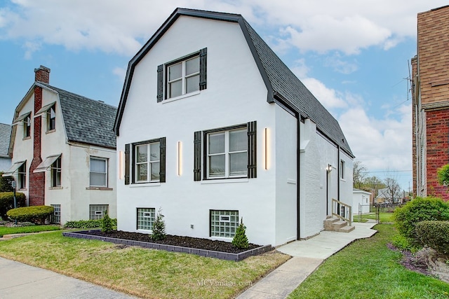 9221 S Lowe Ave, Chicago, IL 60620 - view of home's exterior with stucco siding, a gambrel roof, entry steps, roof with shingles, and a lawn