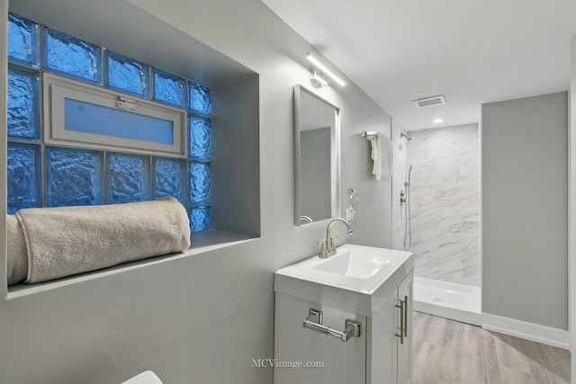 9221 S Lowe Ave, Chicago, IL 60620 - full bathroom with wood finished floors, vanity, visible vents, and tiled shower