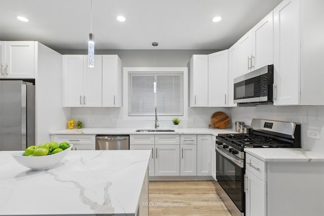9221 S Lowe Ave, Chicago, IL 60620 - kitchen with light wood-style flooring, a sink, white cabinets, and appliances with stainless steel finishes