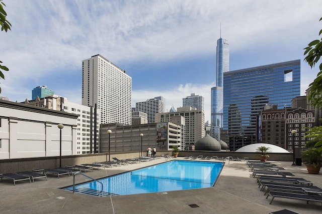 community pool with a view of city and a patio area