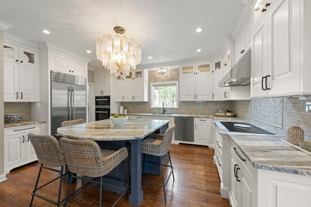 569 Prairie Ave, Glen Ellyn, IL 60137 - kitchen with black appliances, under cabinet range hood, a chandelier, white cabinetry, and a kitchen bar