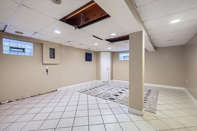 below grade area with a paneled ceiling, recessed lighting, and a healthy amount of sunlight
