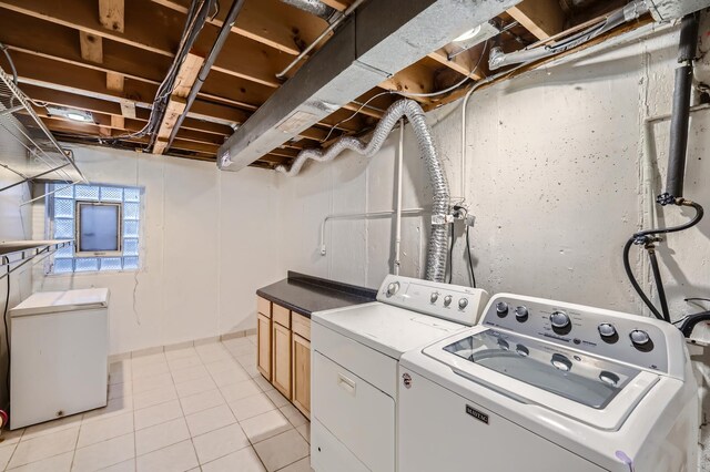 laundry area featuring separate washer and dryer, cabinet space, and light tile patterned floors