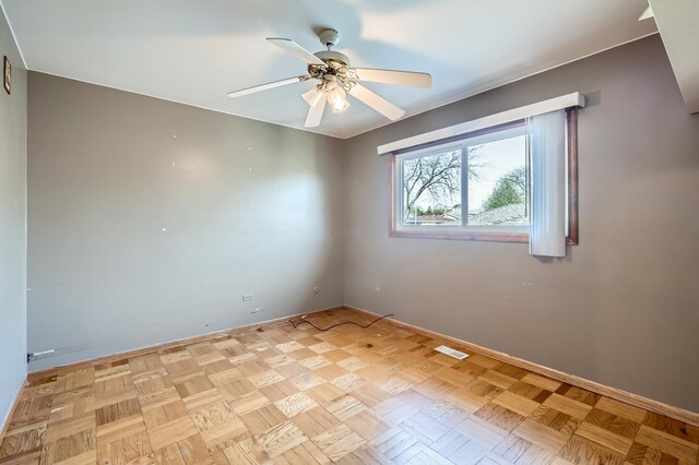 unfurnished room with baseboards, ceiling fan, and visible vents
