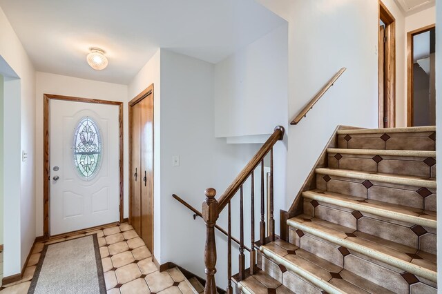 foyer with stairs and baseboards