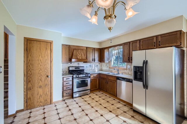 kitchen featuring appliances with stainless steel finishes, a sink, a chandelier, premium range hood, and decorative backsplash