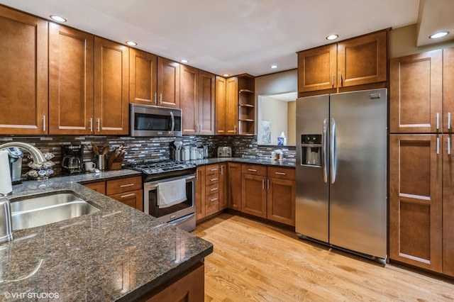 kitchen with light wood-style flooring, open shelves, appliances with stainless steel finishes, brown cabinets, and a sink