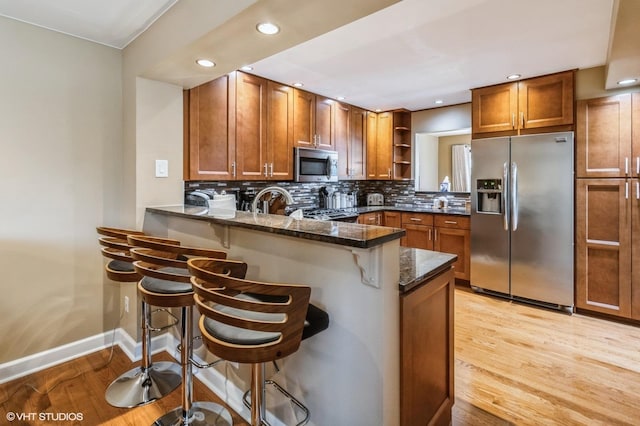 kitchen with appliances with stainless steel finishes, open shelves, and brown cabinetry