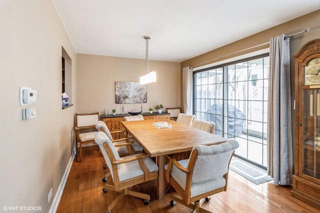 dining area with baseboards and wood finished floors