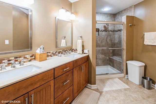 full bath featuring a stall shower, double vanity, decorative backsplash, and a sink