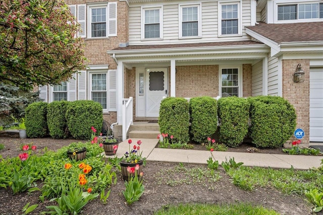 property entrance featuring brick siding and roof with shingles