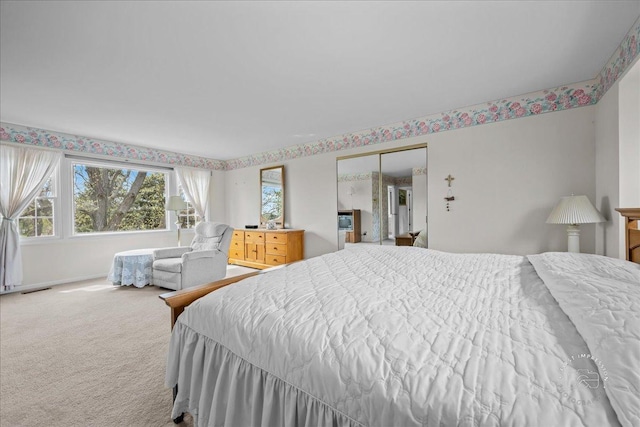 bedroom featuring visible vents, carpet, baseboards, and multiple windows