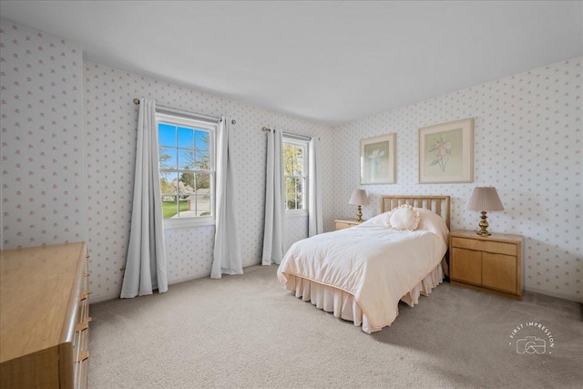 bedroom featuring wallpapered walls and light carpet