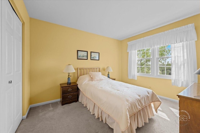 bedroom with carpet flooring, baseboards, and a closet