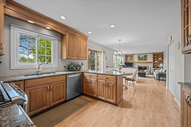 kitchen with stainless steel appliances, an inviting chandelier, plenty of natural light, and a sink