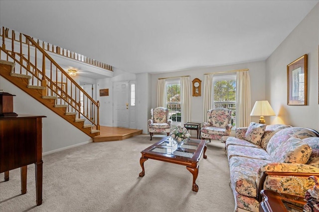 living area with baseboards, carpet flooring, and stairs