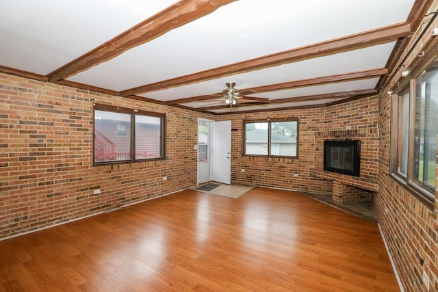 18557 W Country Ln, Grayslake, IL 60030 - unfurnished living room featuring brick wall, light wood-style flooring, beam ceiling, ceiling fan, and a fireplace