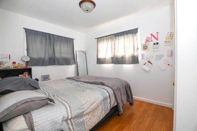 bedroom with baseboards and wood finished floors