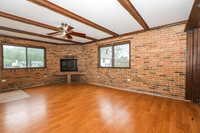 18557 W Country Ln, Grayslake, IL 60030 - unfurnished living room with brick wall, wood finished floors, ceiling fan, beam ceiling, and a brick fireplace