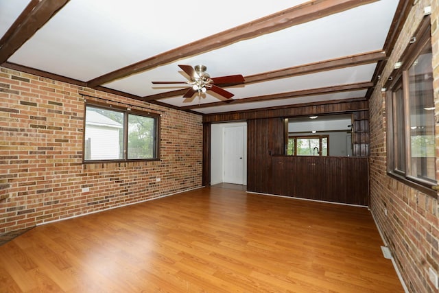 18557 W Country Ln, Grayslake, IL 60030 - unfurnished living room with brick wall, beamed ceiling, wood finished floors, healthy amount of natural light, and a ceiling fan