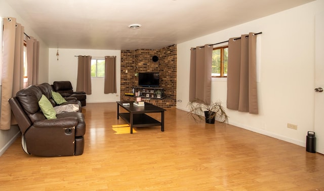 living room featuring baseboards, a wealth of natural light, and light wood-style floors