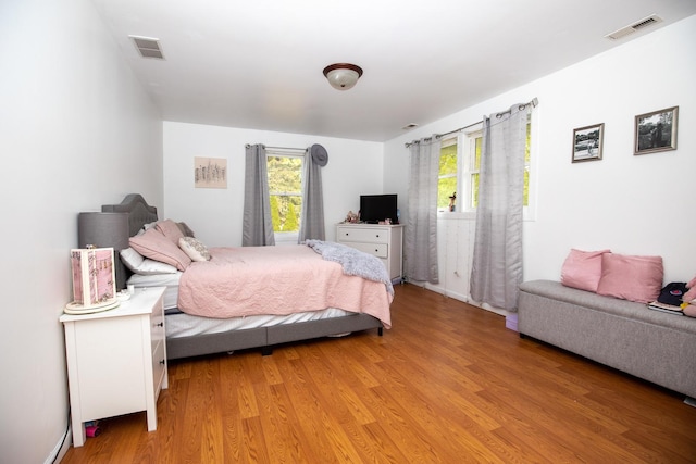 bedroom featuring light wood finished floors and visible vents
