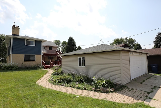 view of side of home with a detached garage, a chimney, a wooden deck, and a lawn