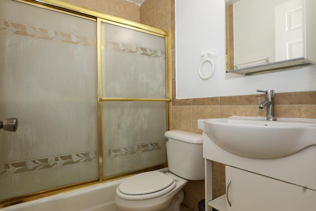18557 W Country Ln, Grayslake, IL 60030 - bathroom featuring bath / shower combo with glass door, toilet, tile walls, vanity, and wainscoting