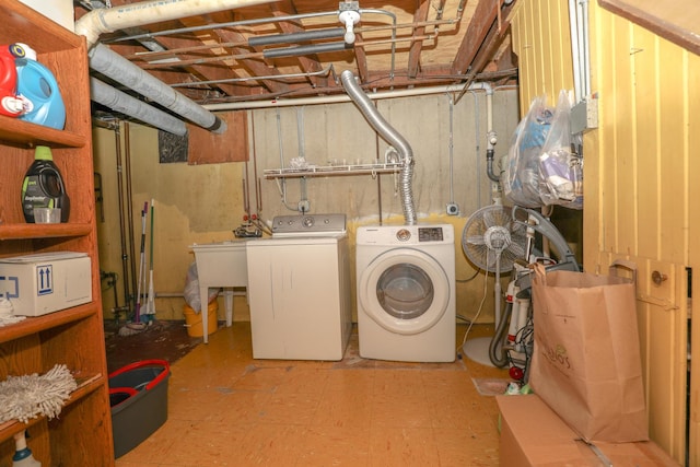 washroom with washing machine and clothes dryer, laundry area, and light floors