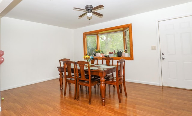 dining area featuring baseboards, light wood-type flooring, and ceiling fan