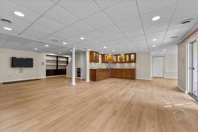 unfurnished living room with light wood-style floors, baseboards, and visible vents