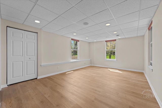 unfurnished bedroom featuring baseboards, light wood finished floors, and multiple windows