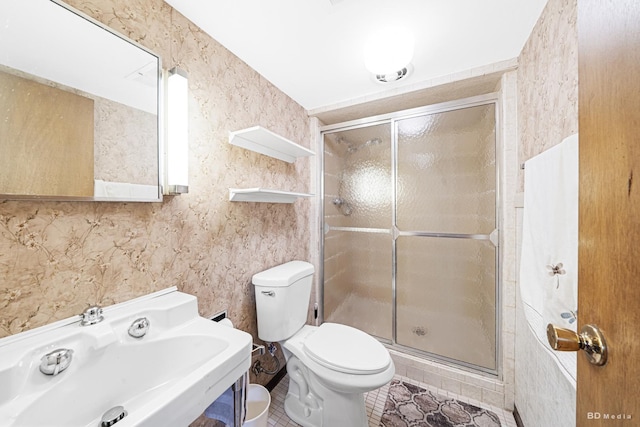 bathroom with a sink, a shower stall, toilet, and tile patterned flooring