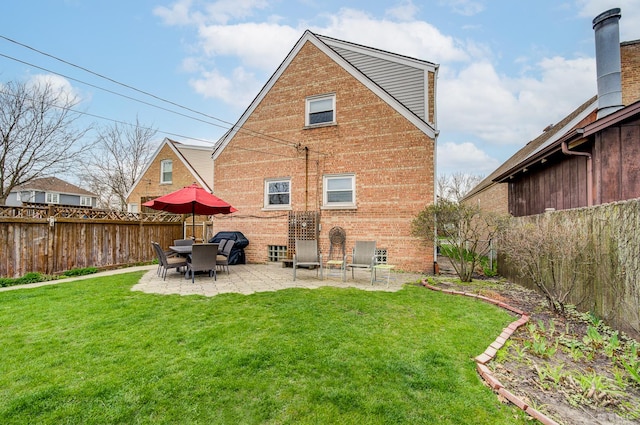 rear view of property featuring brick siding and a patio