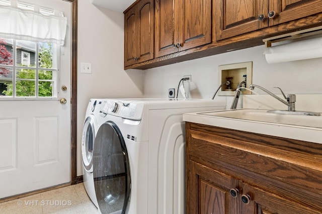 laundry room featuring a sink, light tile patterned floors, washing machine and dryer, and cabinet space