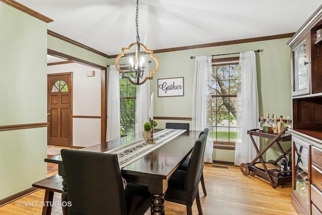 dining area with baseboards, a notable chandelier, a healthy amount of sunlight, and light wood finished floors