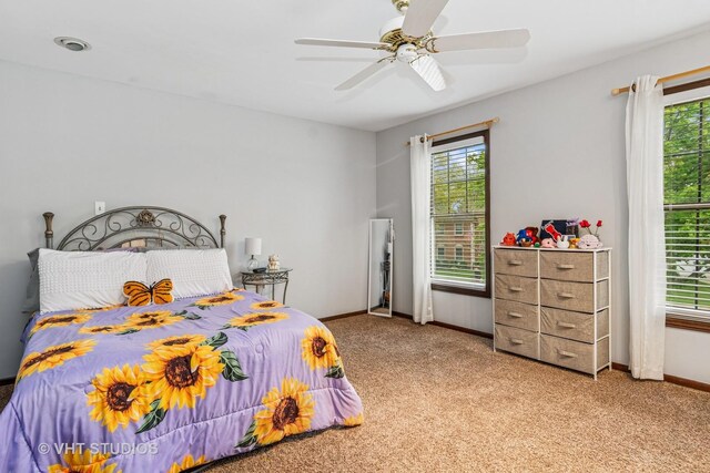 bedroom featuring baseboards, multiple windows, and carpet