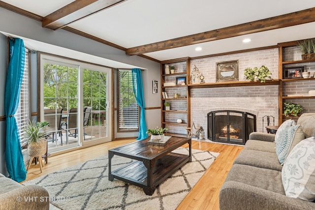 living room featuring beamed ceiling, a brick fireplace, recessed lighting, and wood finished floors
